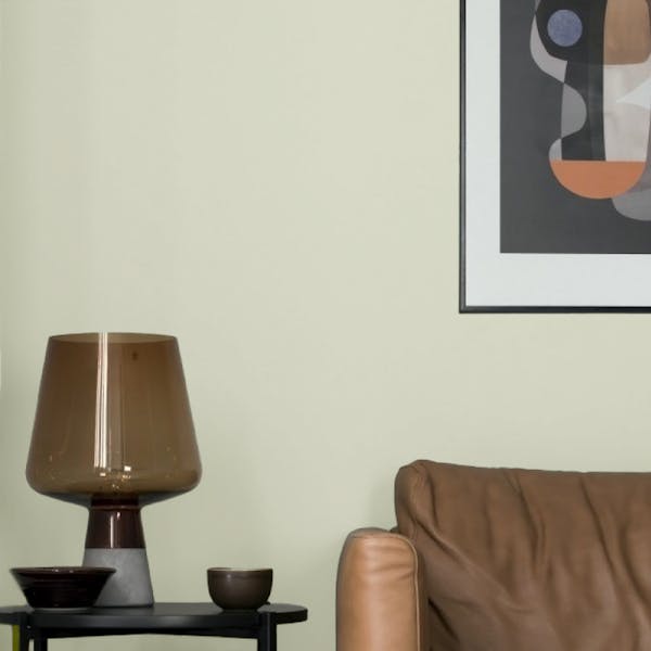 couch and table lamp against pale green wall painted in taffeta f383