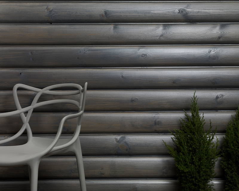 Chair and small tree in front of pearlescent grey wooden wall