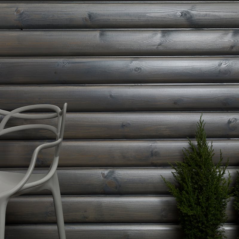 Chair and small tree in front of pearlescent grey wooden wall