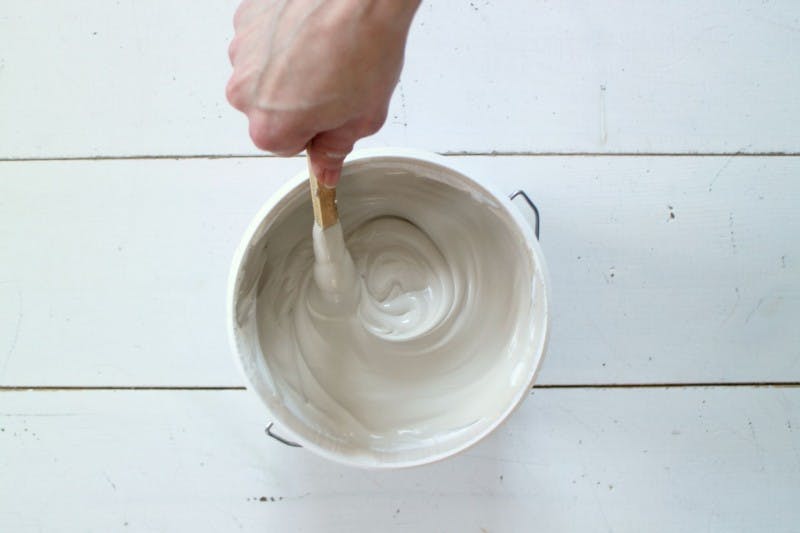 Stirring White Paint with Wooden Stick