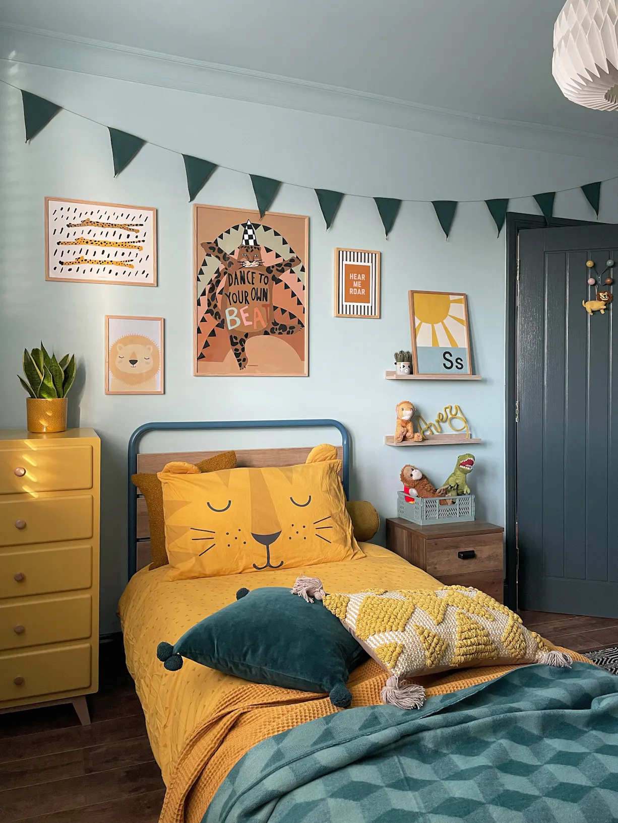 finished bedroom image blue walls yellow bedding with prints and personal items