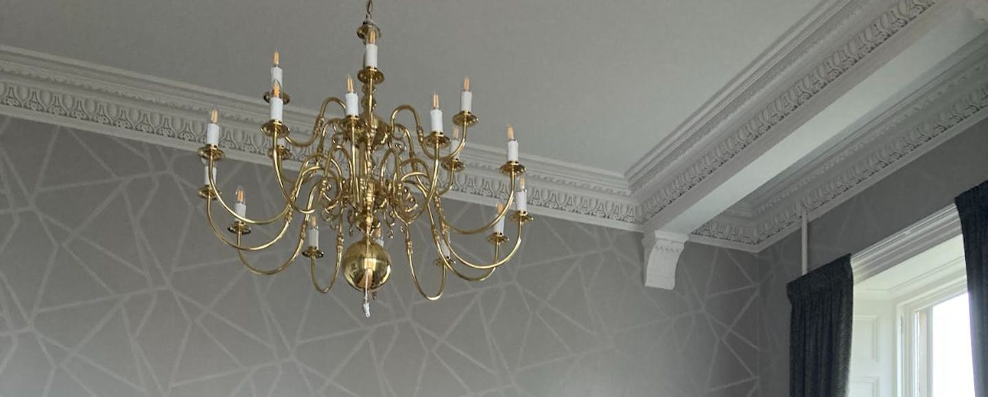 grey room with gold chandelier 