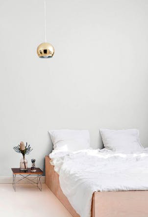 bright and open bedroom with a white-grey wall