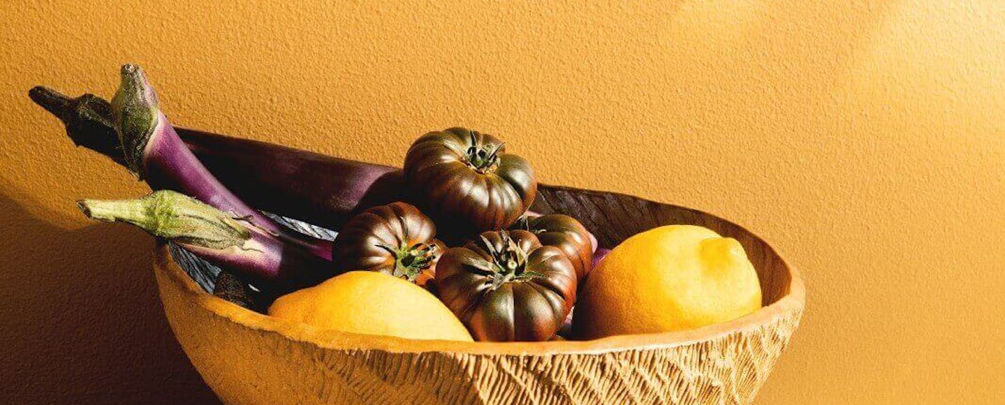 fruit bowl in front of bright orange wall