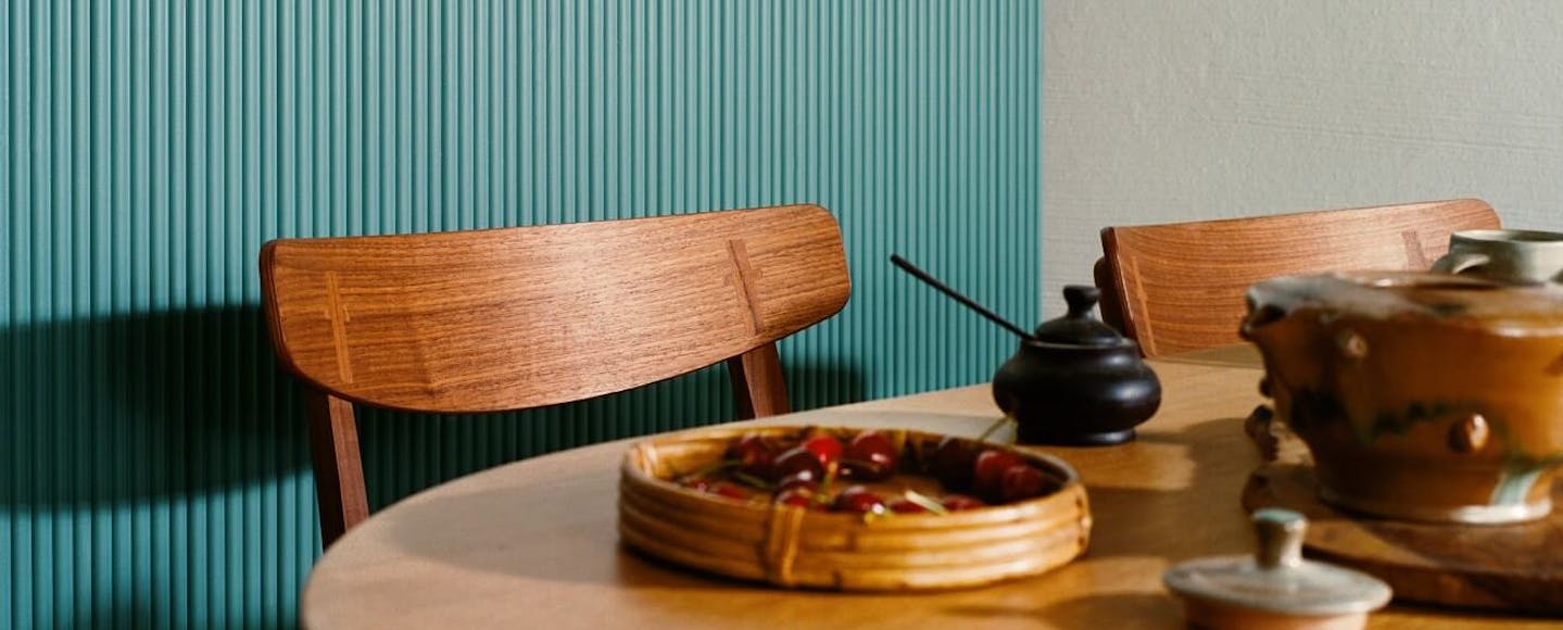 wooden furniture in front of blue green wall panelling