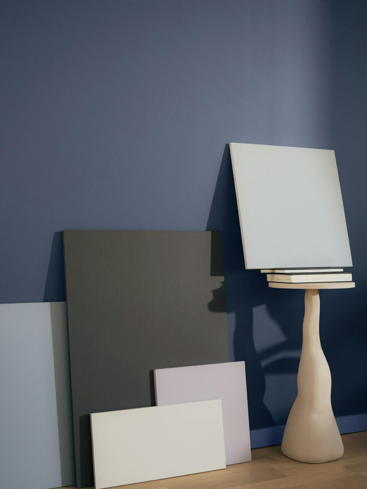 display of painted plinths with dark blue background and leaning against wall