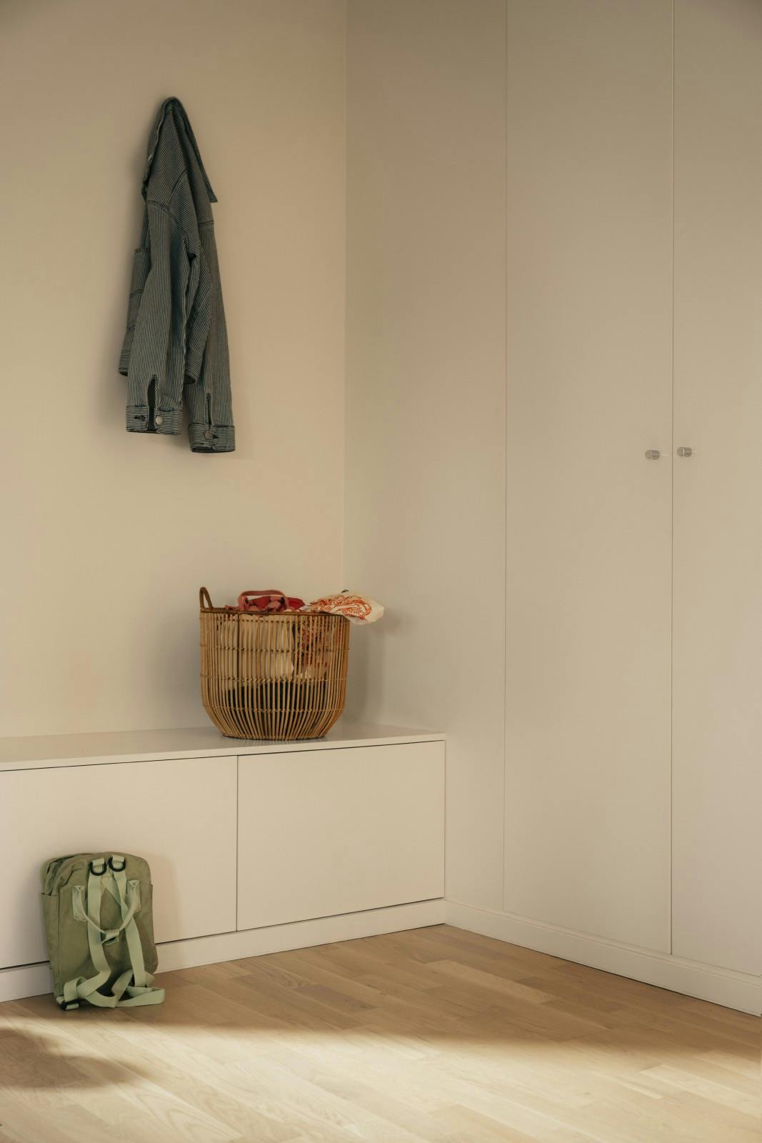 close up view of interior corner with neutral colour scheme and hanging coat on wall