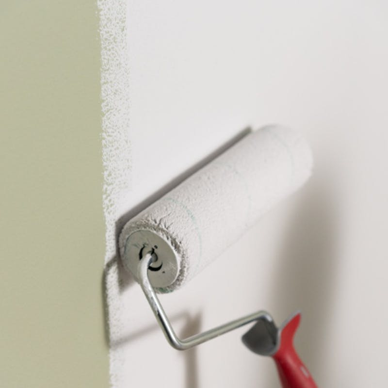 paint roller priming over green shade in white