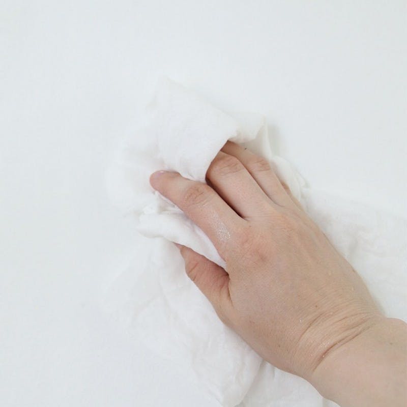 Hand Cleaning White Wall with White Cloth