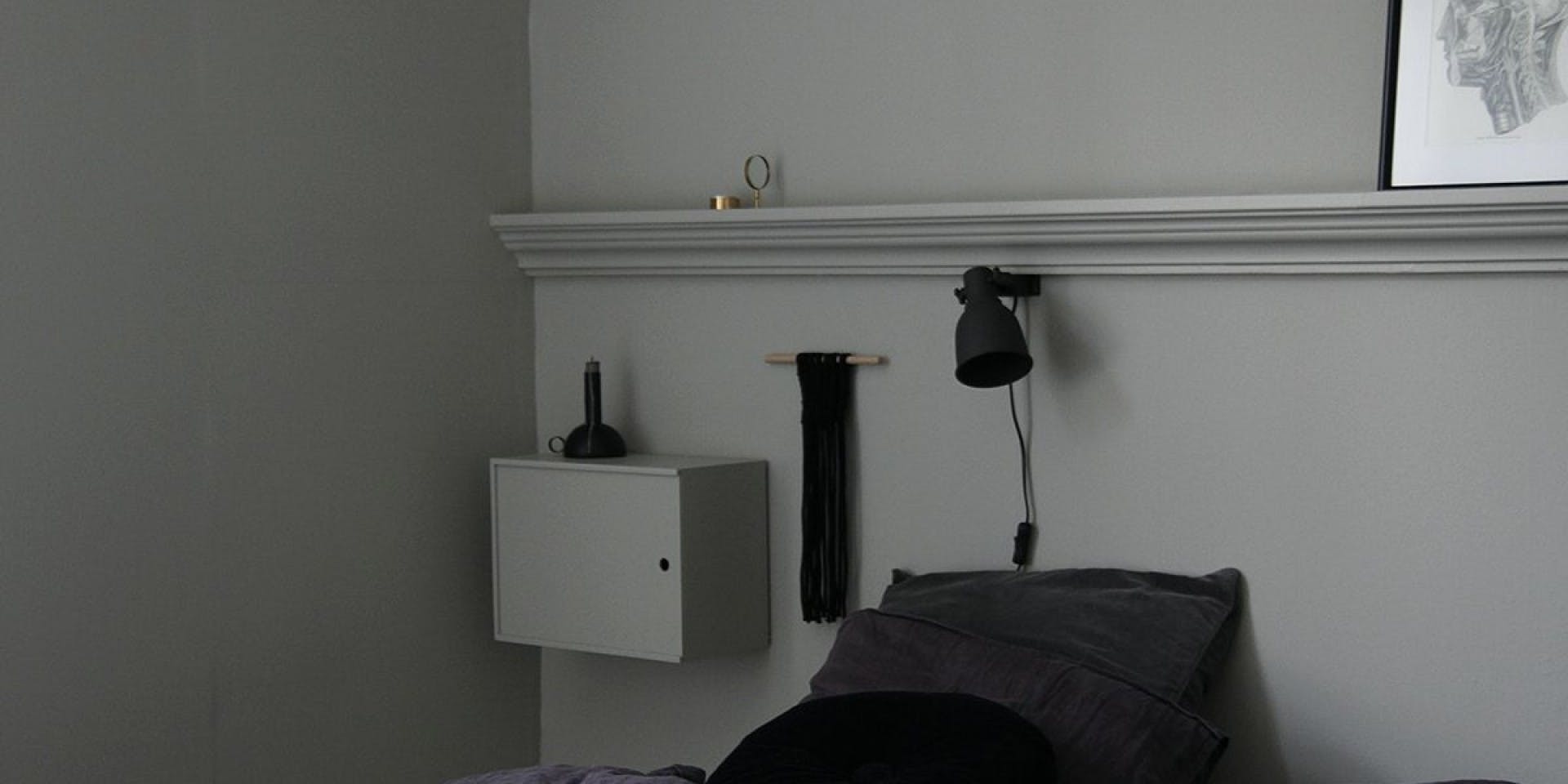 White Bedding Against Light Grey Wall, Black Side Cabinet and Black Lamp