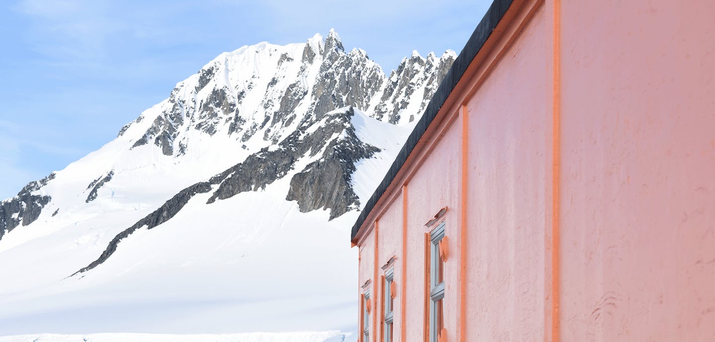 orange hut in front of snowy mountain