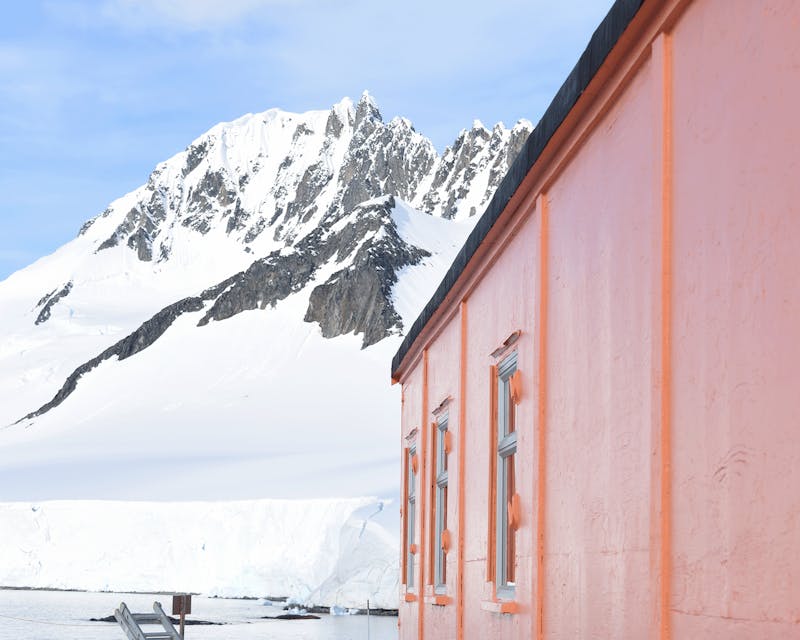 orange hut in front of snowy mountain