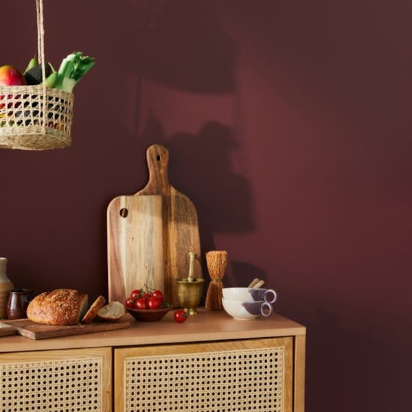 kitchen items on a wooden cabinet against deep red wall
