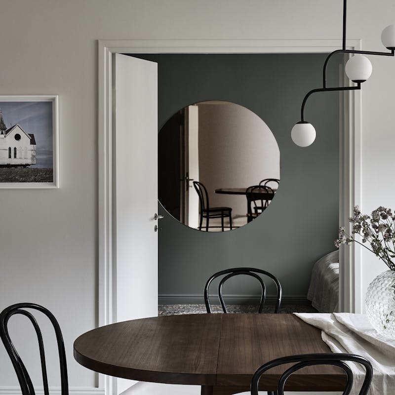 White Room with Dark Brown Dining Table and Three Chairs and Mirror
