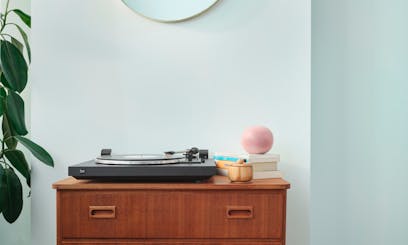 wooden cabinet with record player against light green wall painted in shade crystal g371