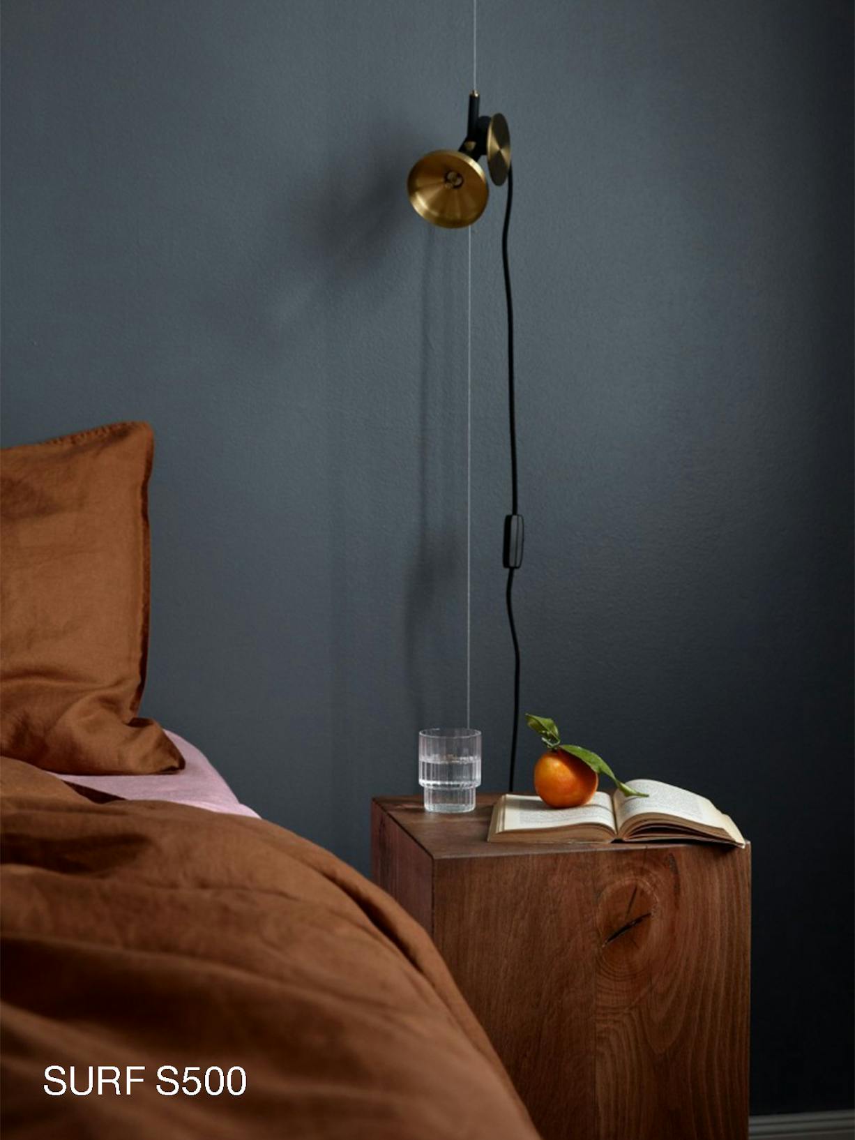 Deep Blue Bedroom With Rusty Brown Bedding and Wooden Side Table and Orange on Top