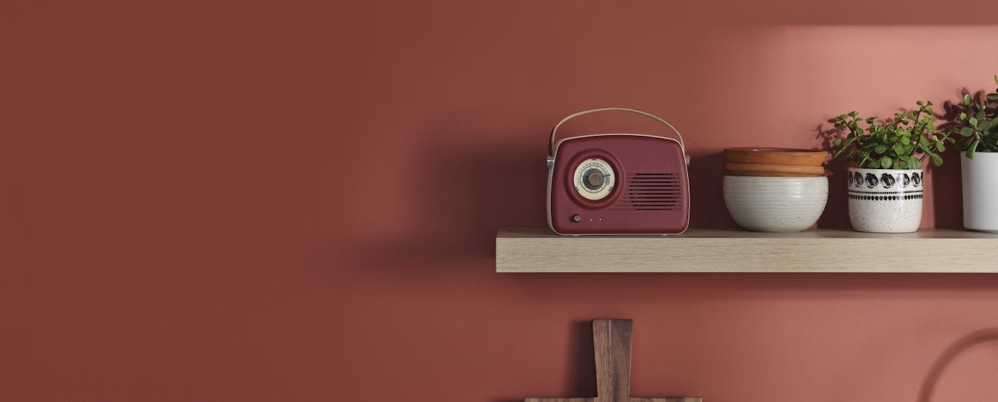 red radio and pots on a wooden shelf against red wall painted in madras n411