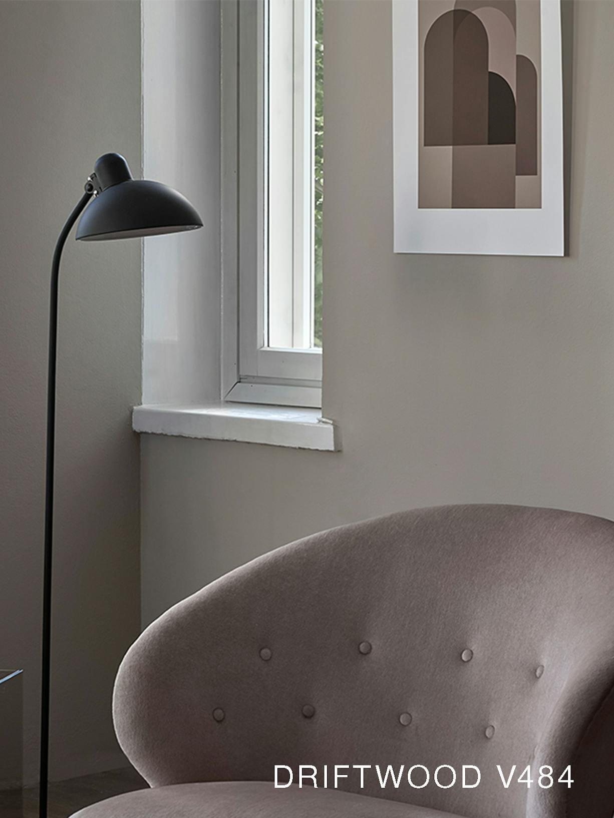 Grey Armchair and Black Lamp Against Neutral Wall with White Window