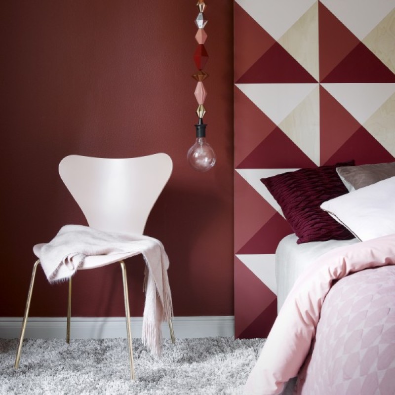 red bedroom with white chair and bed