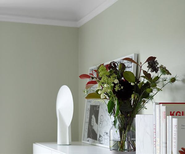 Fresh flowers in front of green bedroom wall