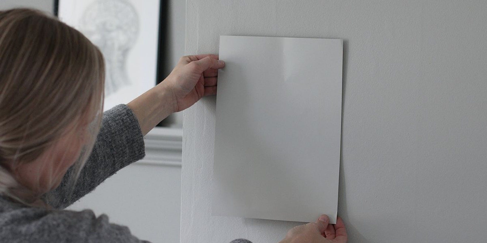 Woman Holding White Card Against White Wall
