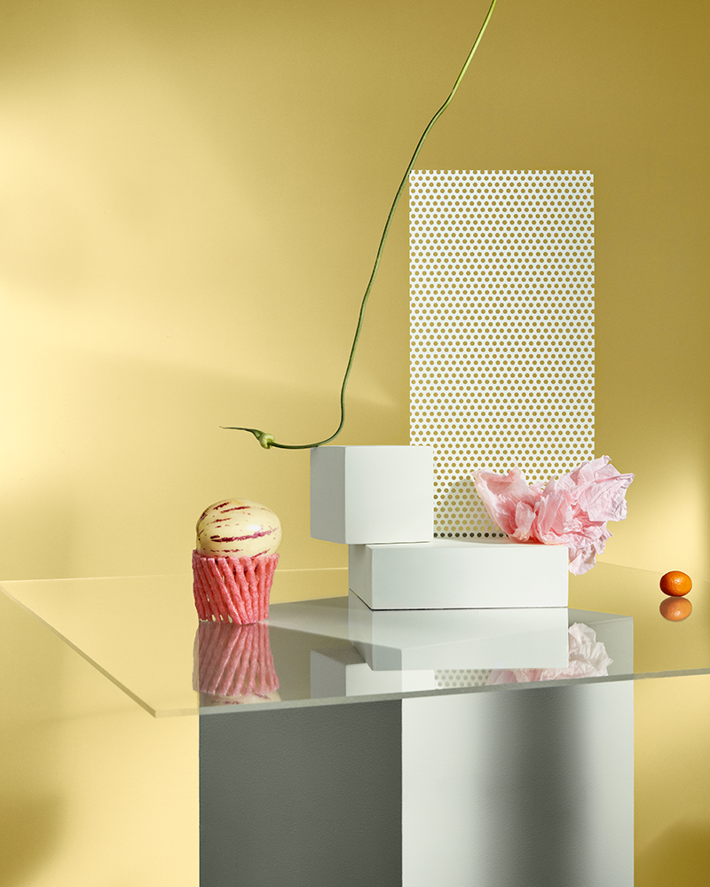 Glass Table with Pink and White Decorations Against Yellow Wall
