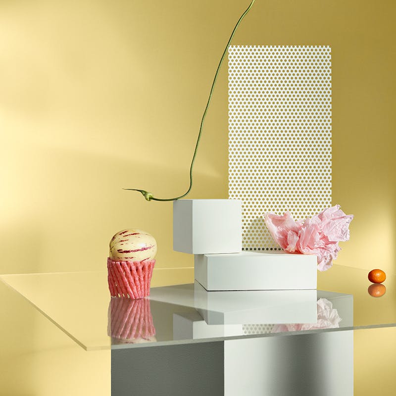 Glass Table with Pink and White Decorations Against Yellow Wall