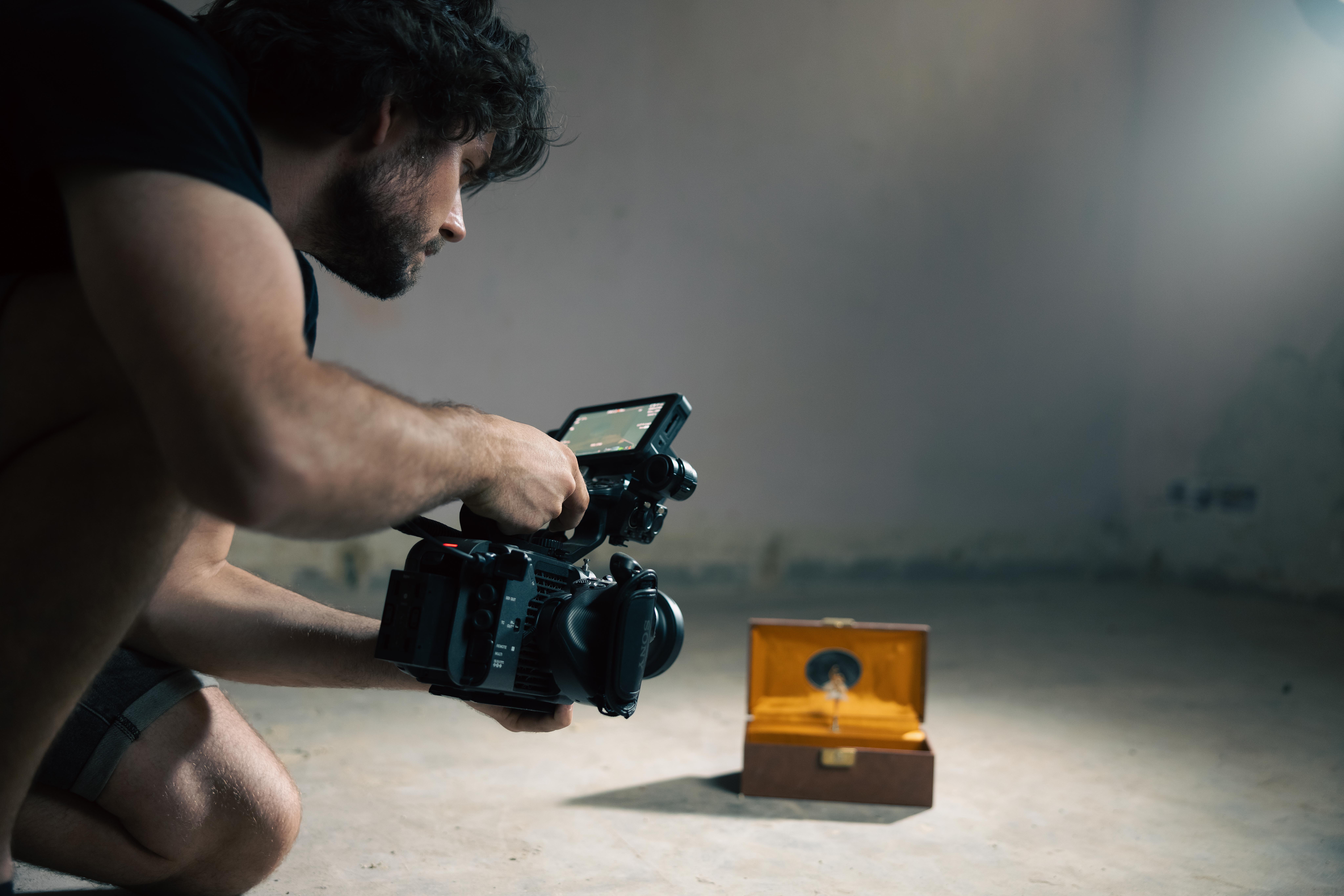 Cameraman films a ballerina figurine as it turns in a music box