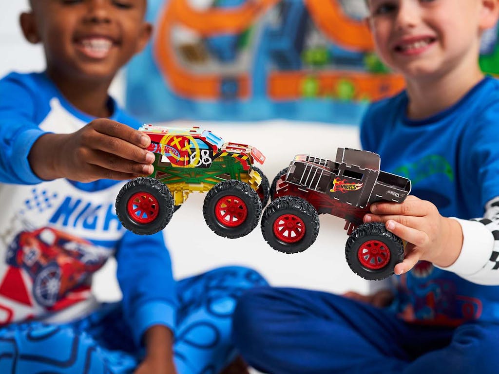 Kids holding Hot Wheels monster trucks