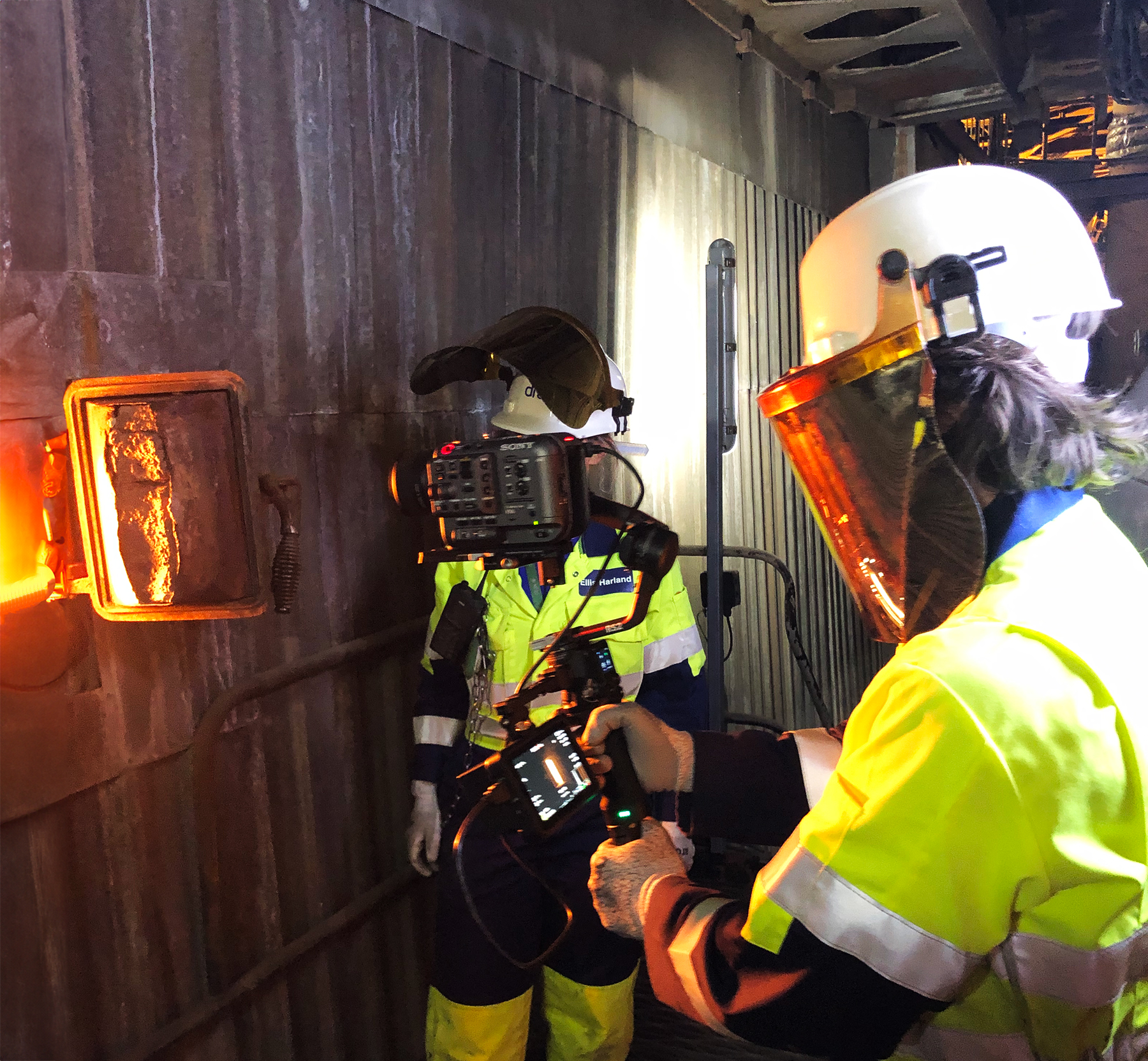 a cameraman film inside a hatch of an industrial boiler