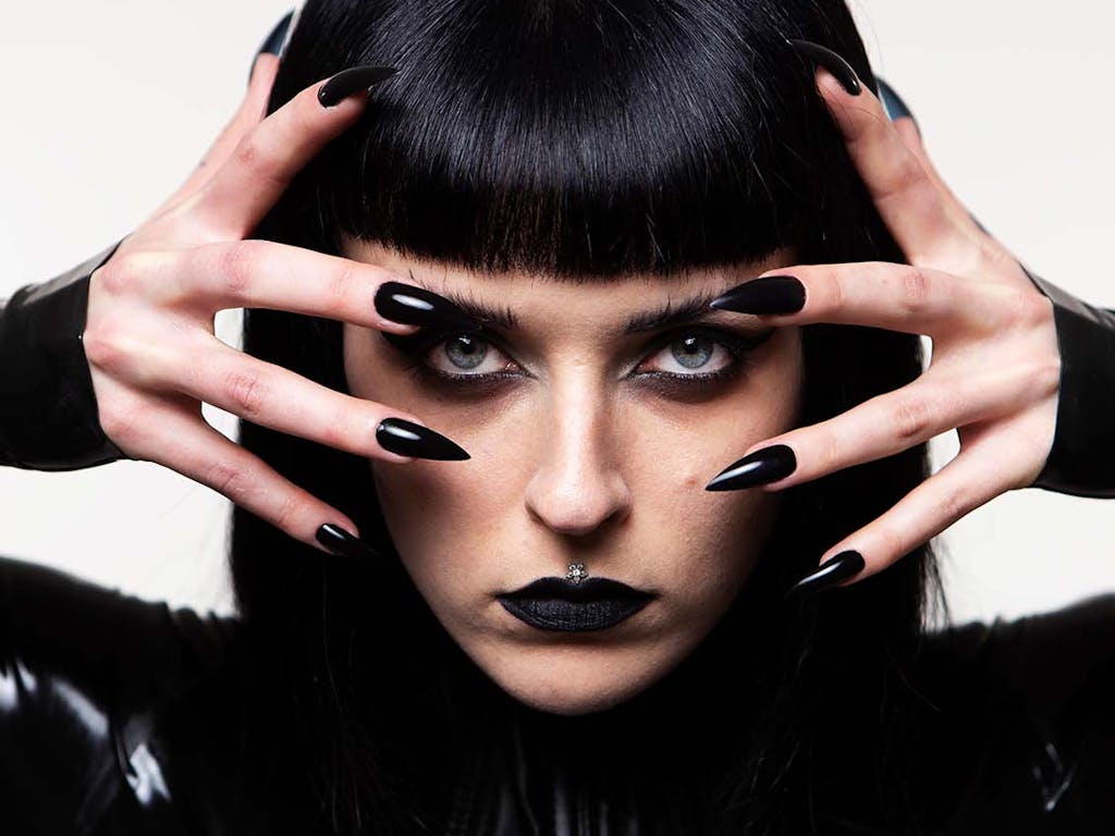 Press PR photography of musician Harpy dressed in black latex with long sharp black nails