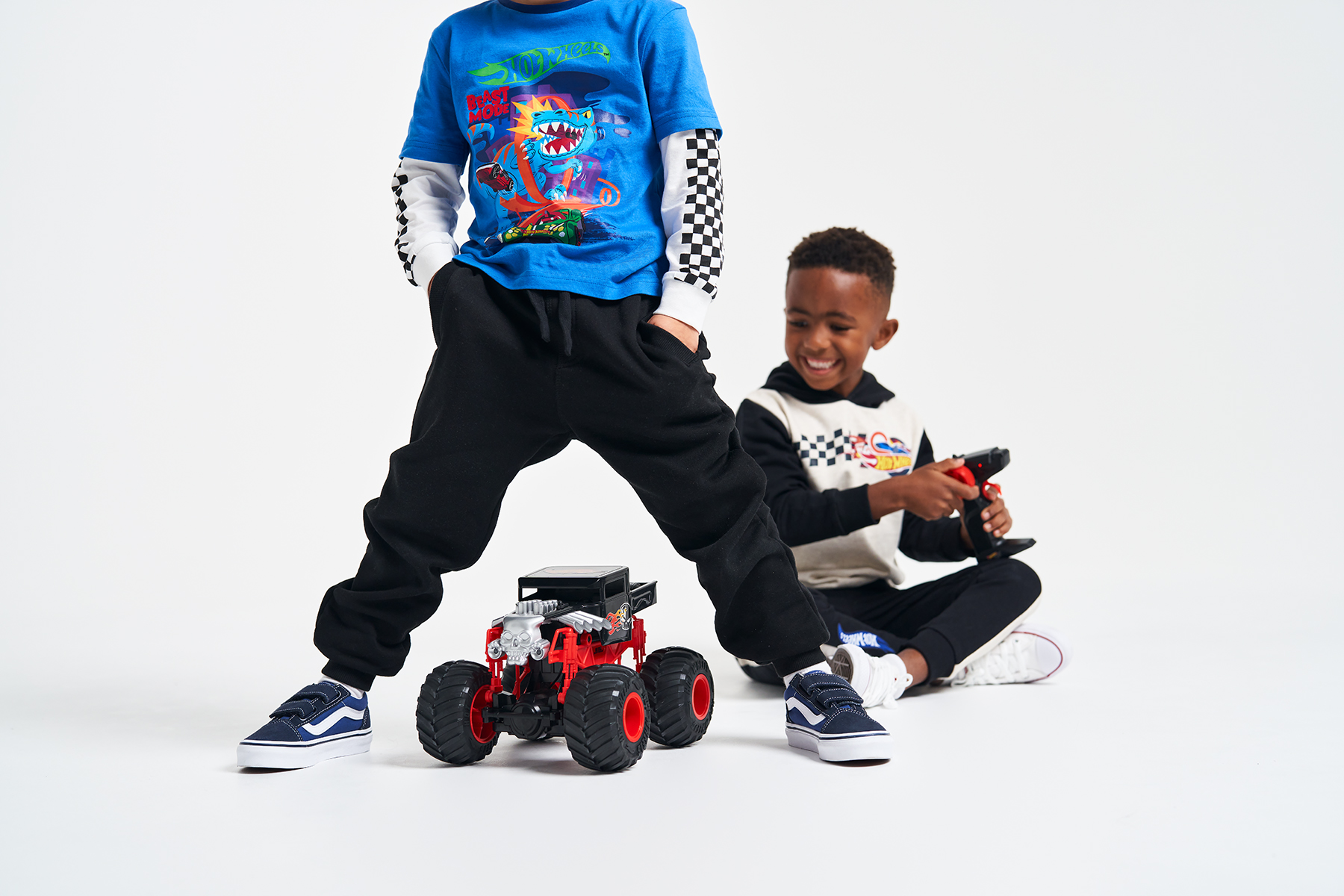Two young boys smiling with Hot Wheels remote controlled car between them