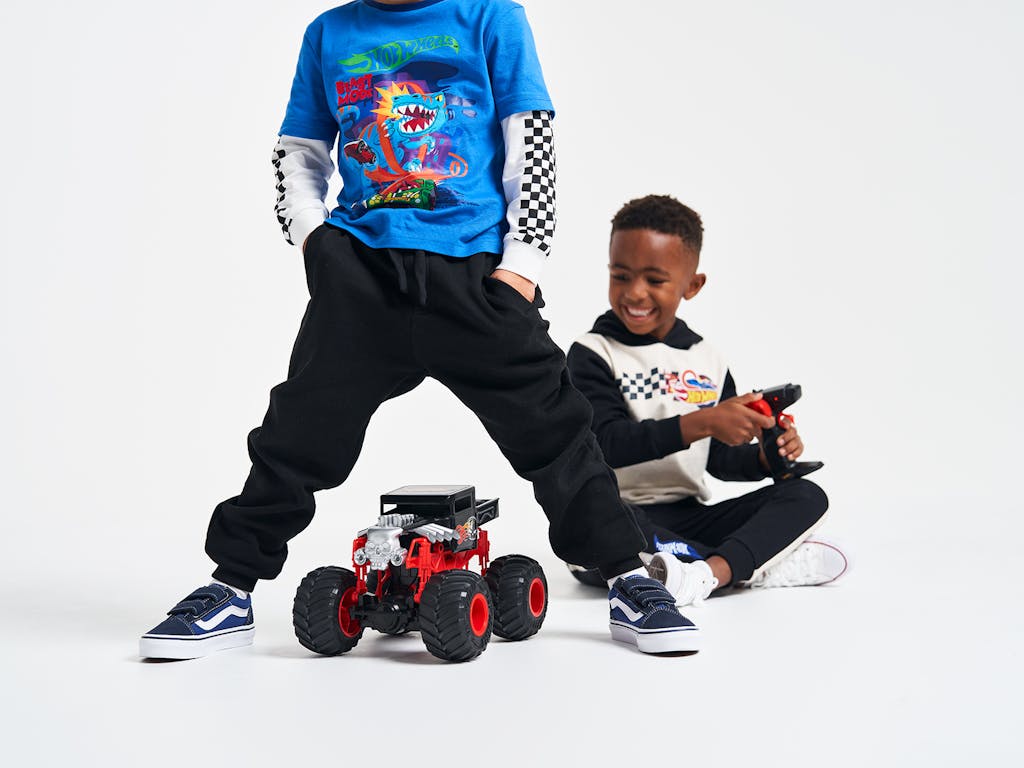 Two young boys smiling with Hot Wheels remote controlled car between them