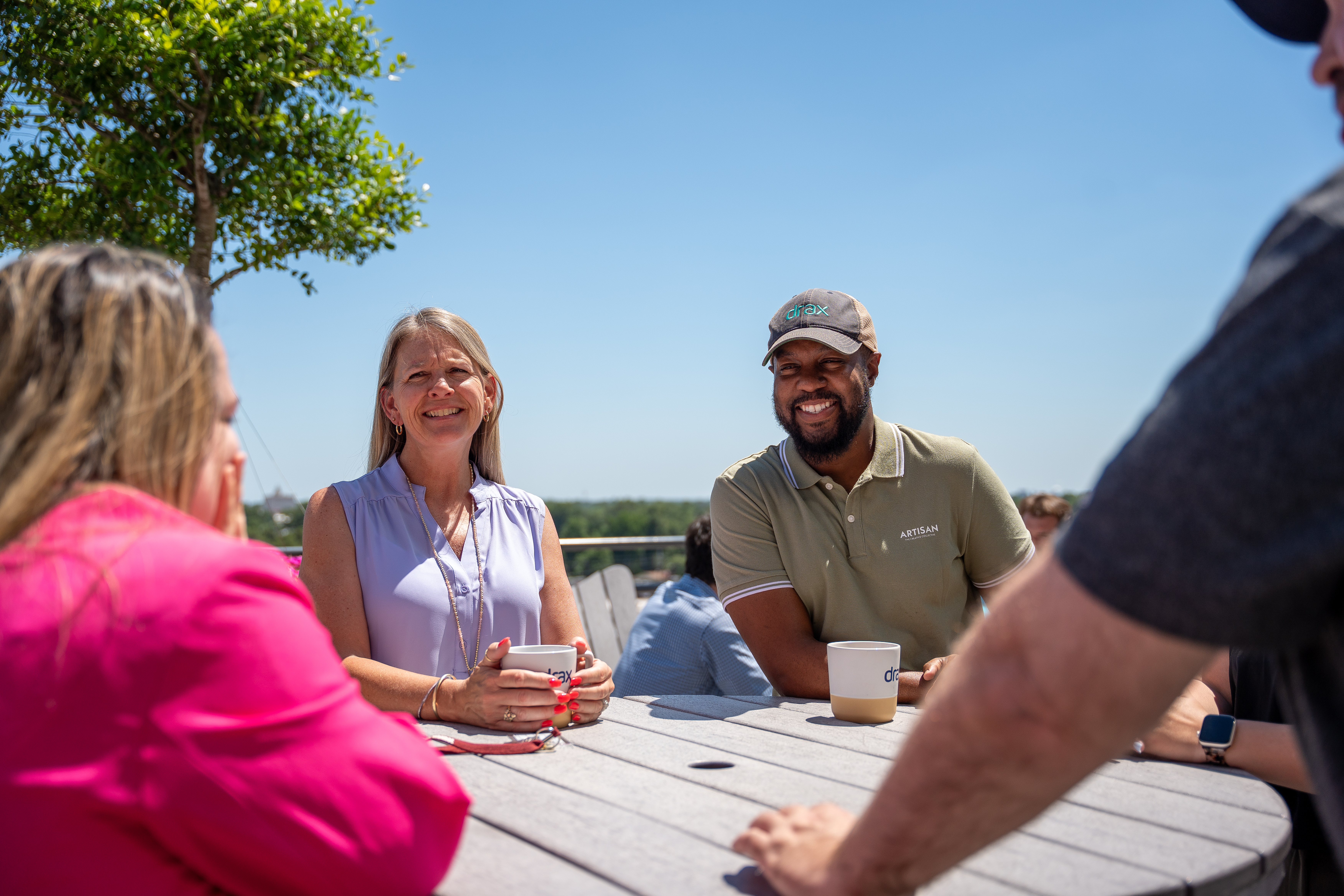 colleagues on a cofee break, sitting in the sunshine