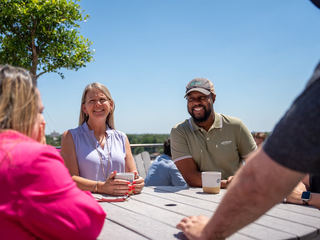 colleagues on a cofee break, sitting in the sunshine