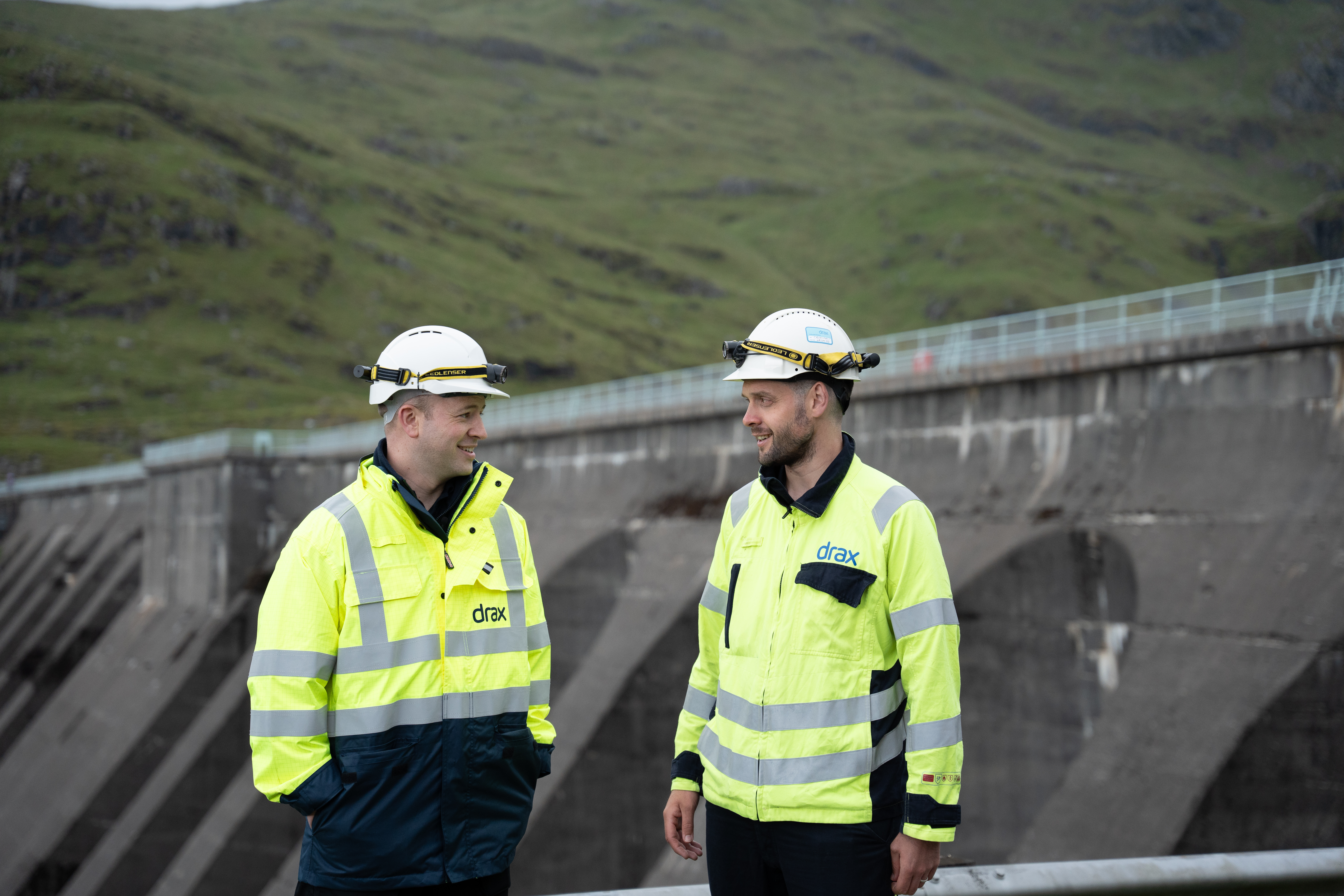2 engineers standing in front of a dam