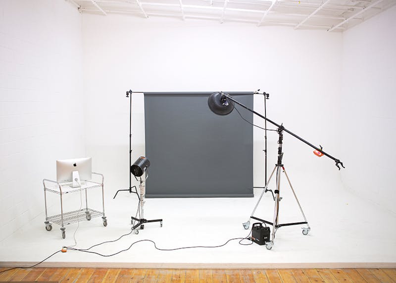 White photography studio with some lights and a grey backdrop