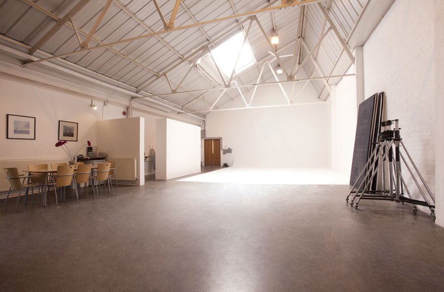 Industrial loft space with white photography setup at the far end