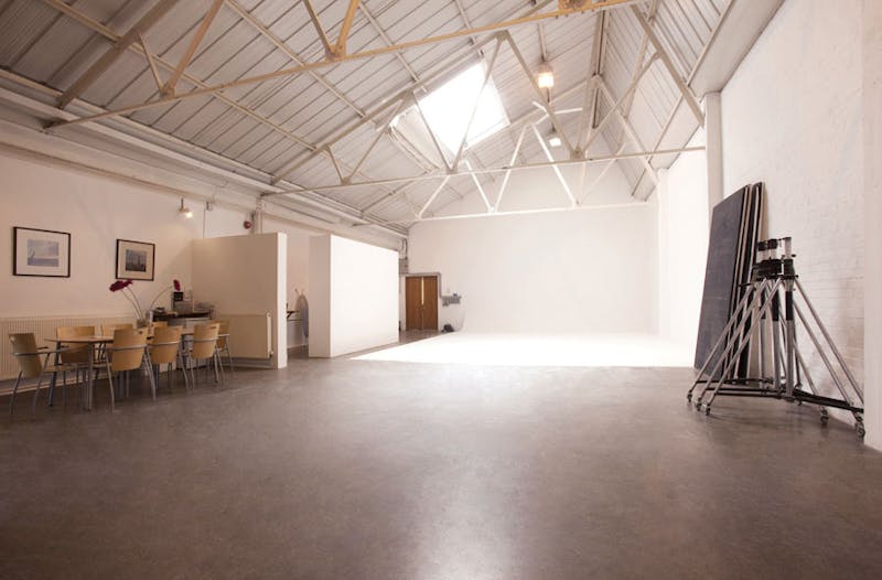 Industrial loft space with white photography setup at the far end