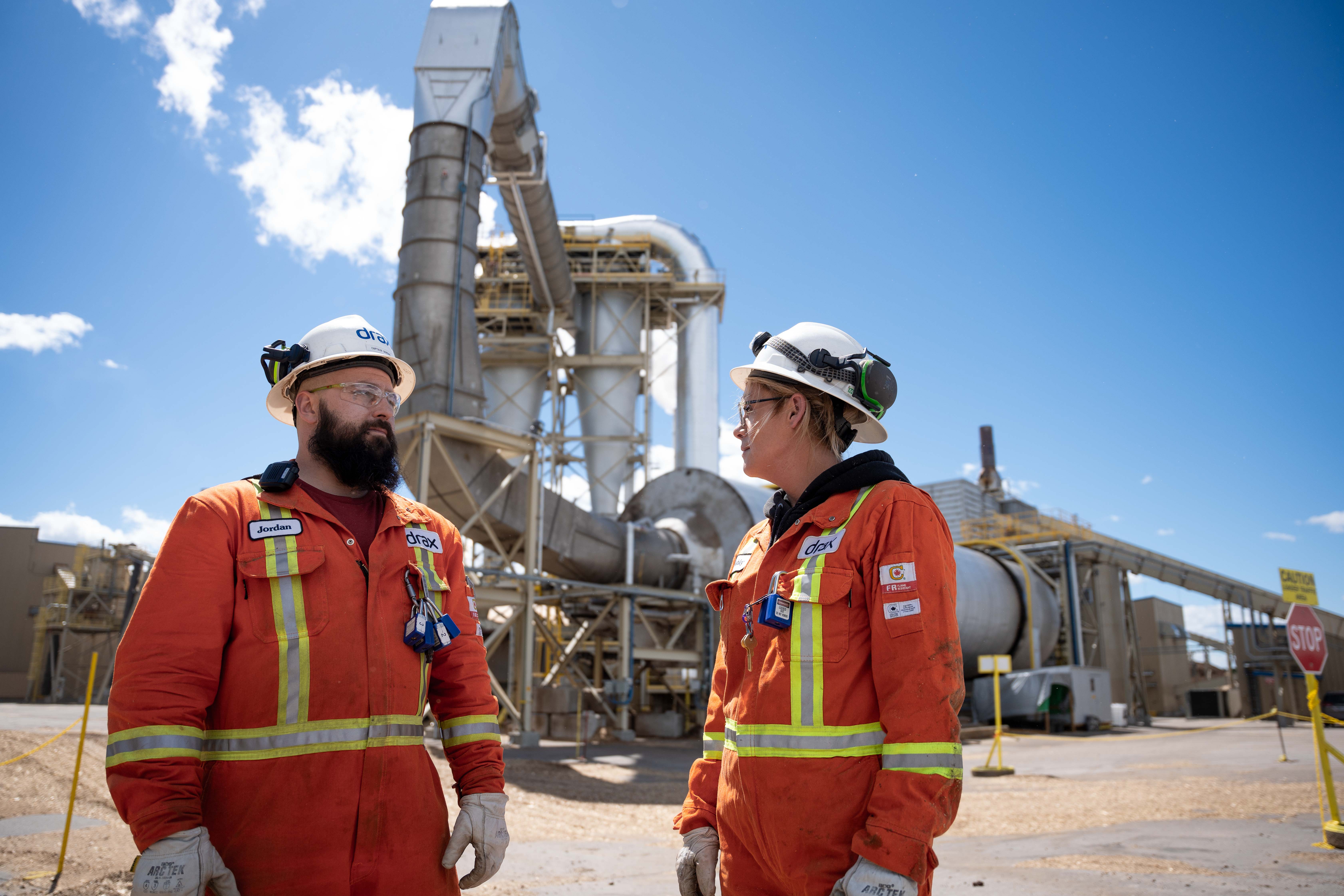 Engineers stood infront of a pellet mill