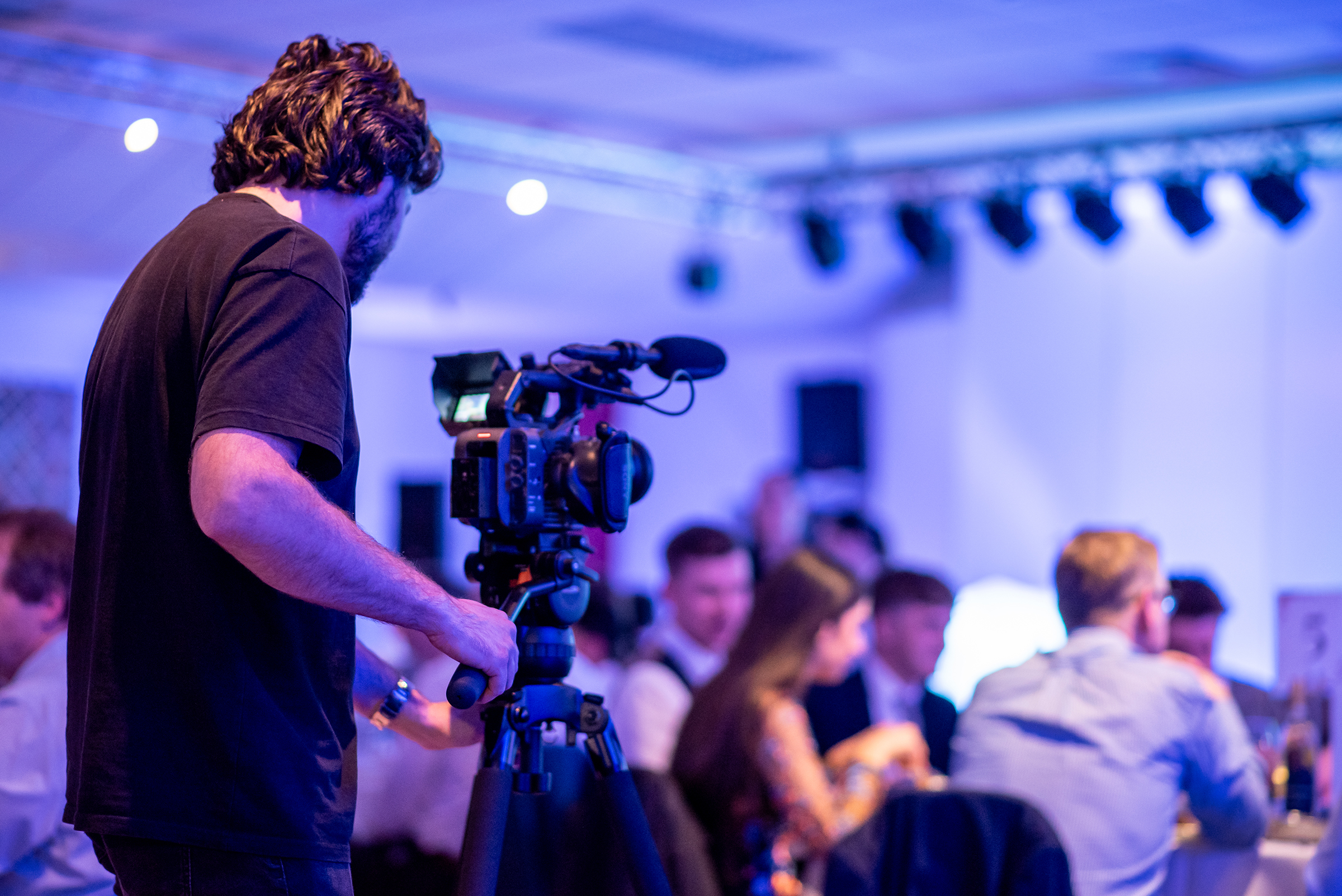 Cameraman filming corporate event, awards evening, sit down dinner