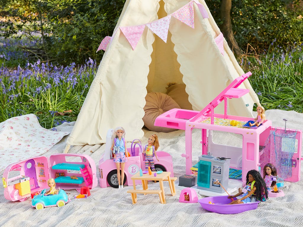 Barbie toys set up on blankets in a woodland picnic