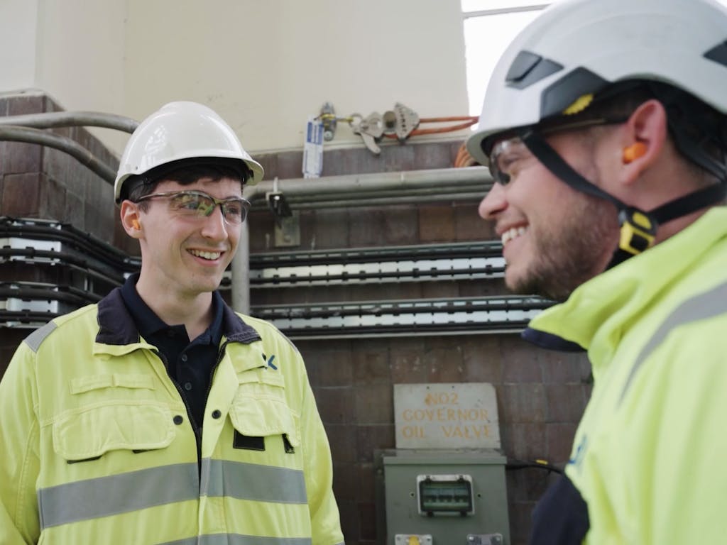 Two Engineers dressed in high-vis talking and smiling