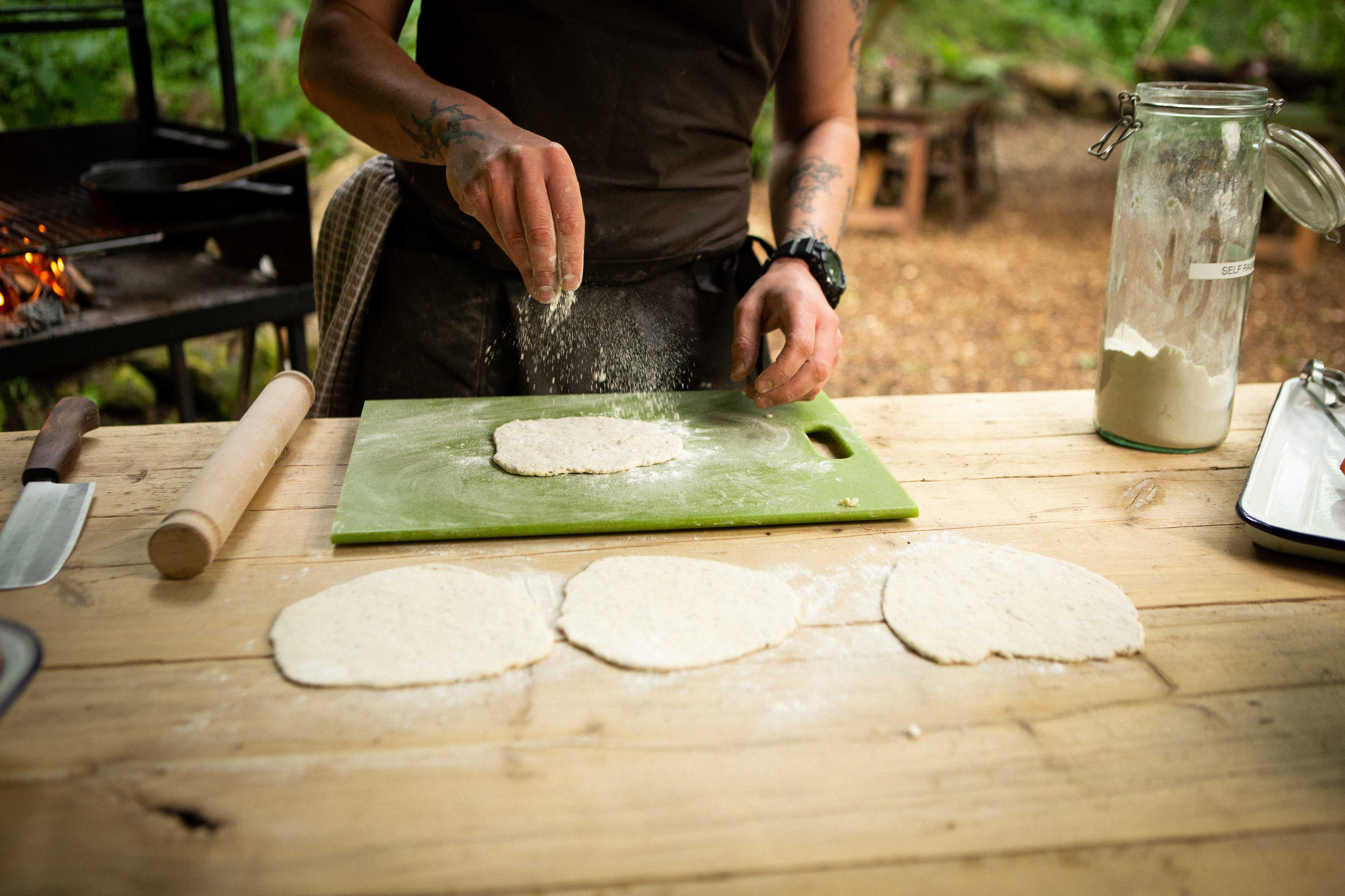chef rolling dough into small round flat breads