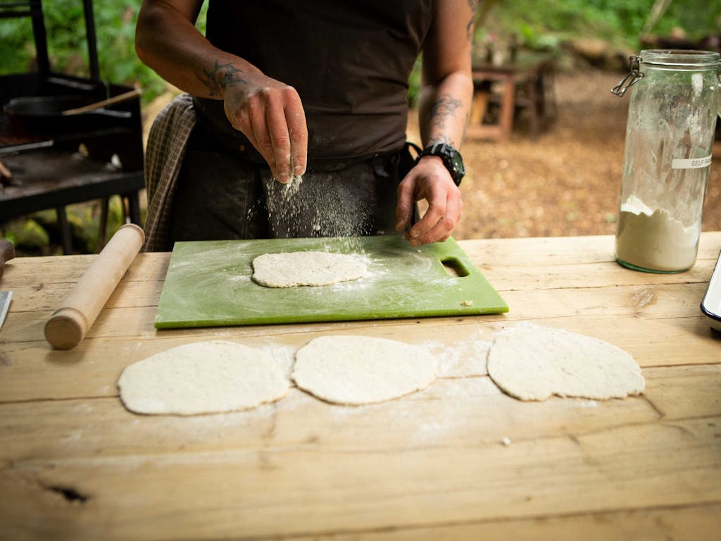 chef rolling dough into small round flat breads