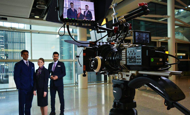 Video camera filming three corporate professionals