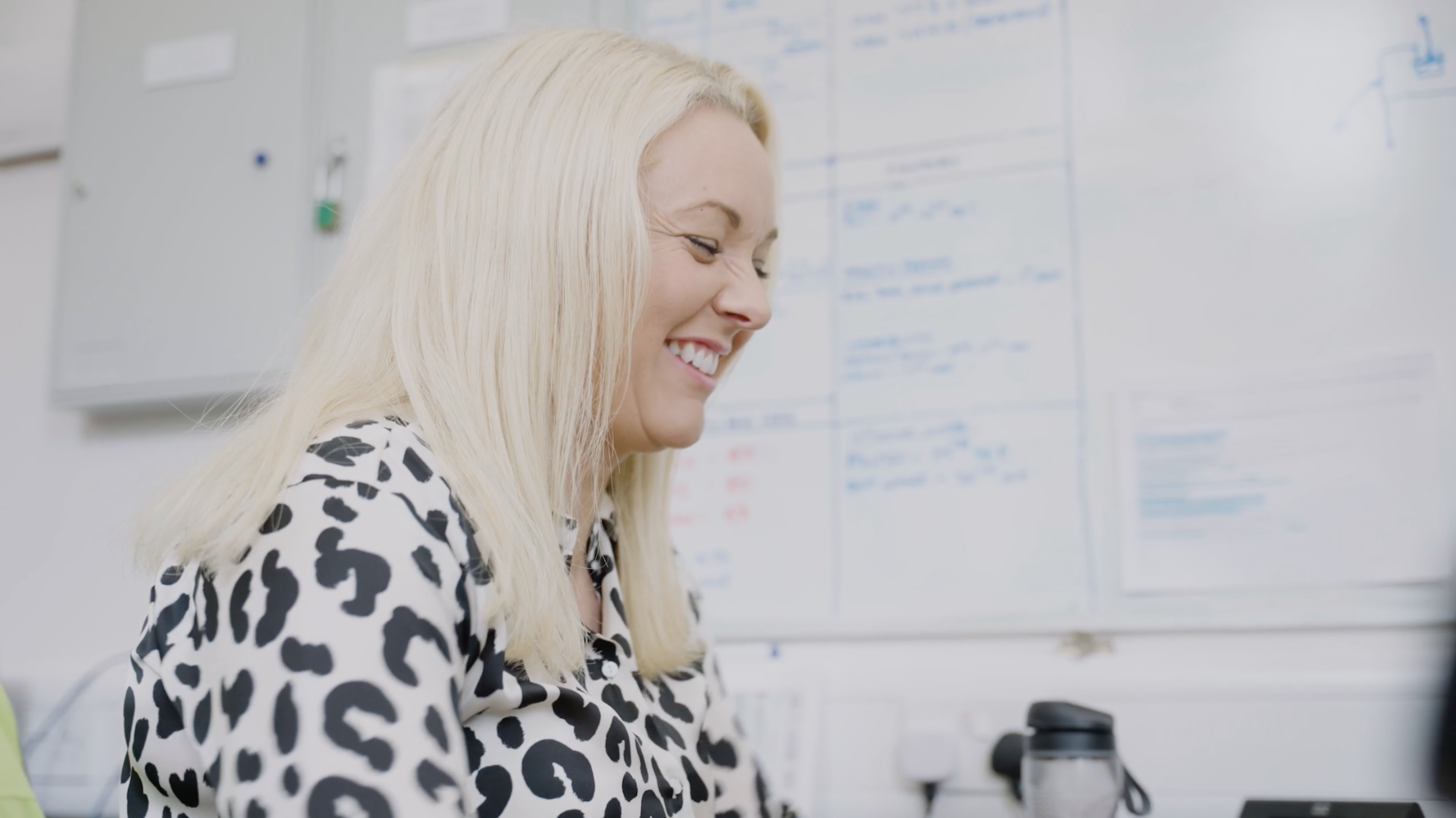 Blonde corporate lady smiling whilst looking at her computer