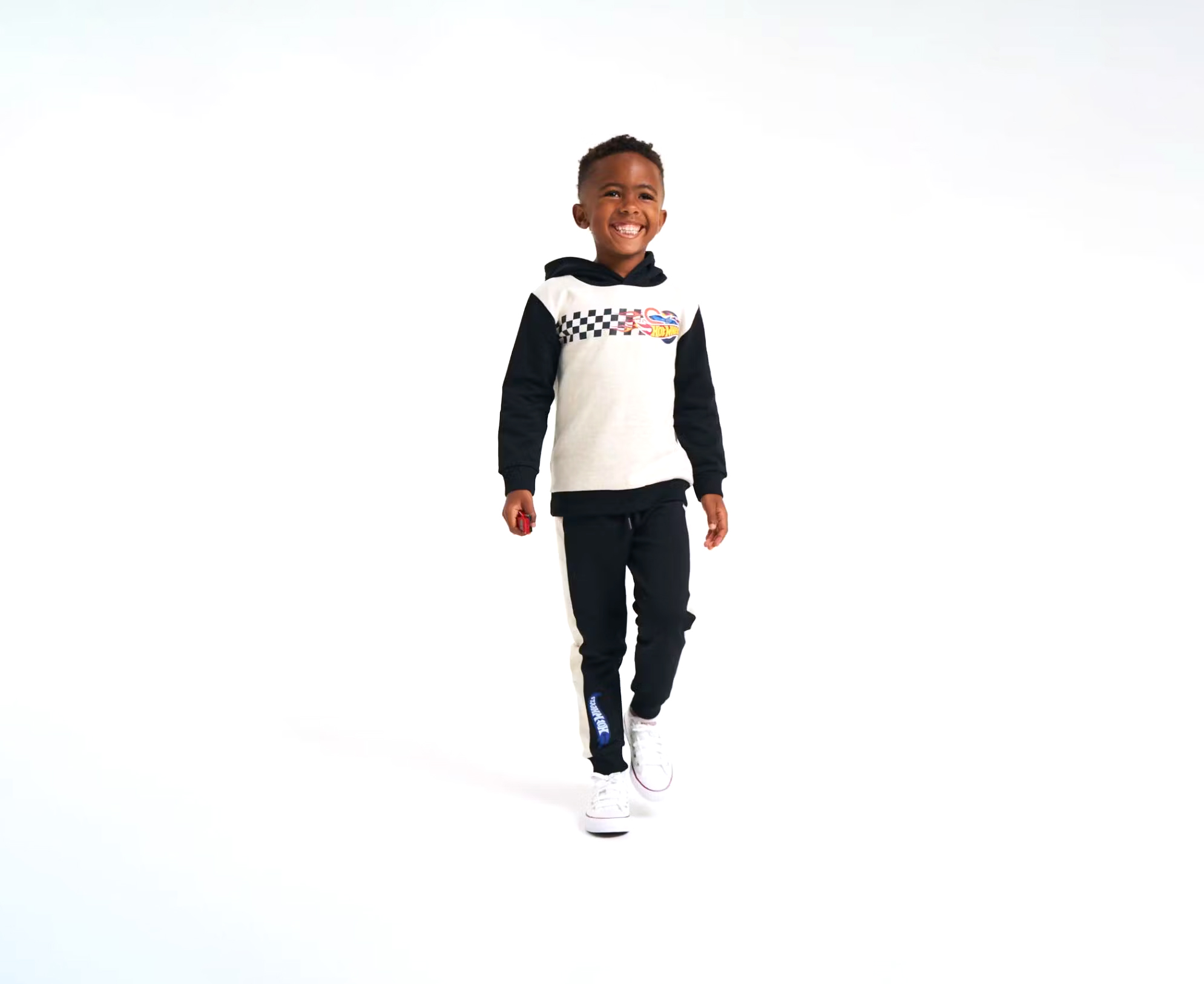 Young boy modelling Hot Wheels tracksuit in a white photography studio
