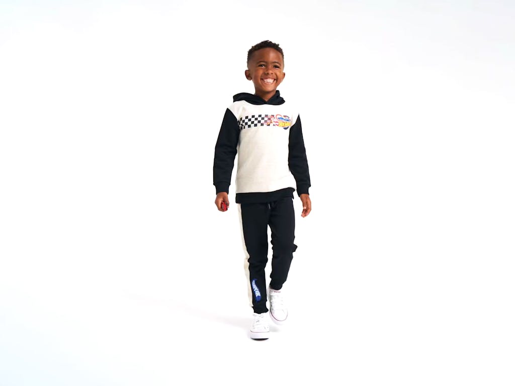 Young boy modelling Hot Wheels tracksuit in a white photography studio