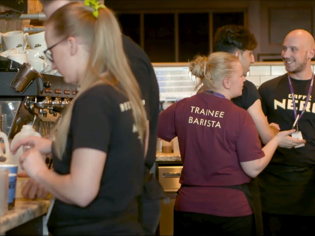 Caffè Nero baristas making coffee and serving customers